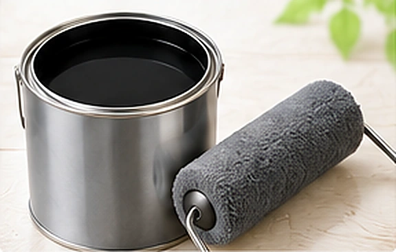 濃い色の塗料缶とローラーのイメージ